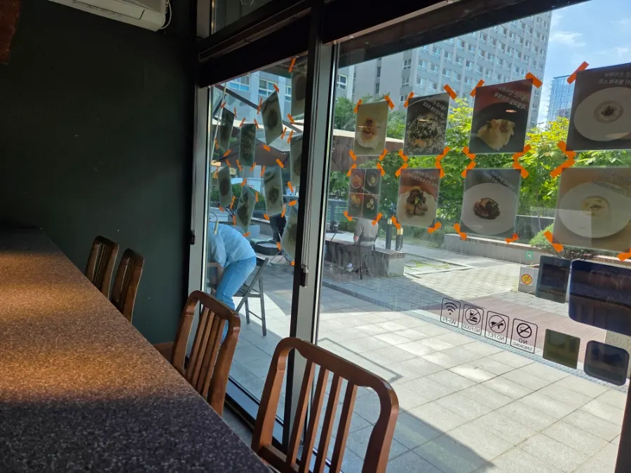 Interior of Don Tamguso with green scenery visible through floor-to-ceiling windows