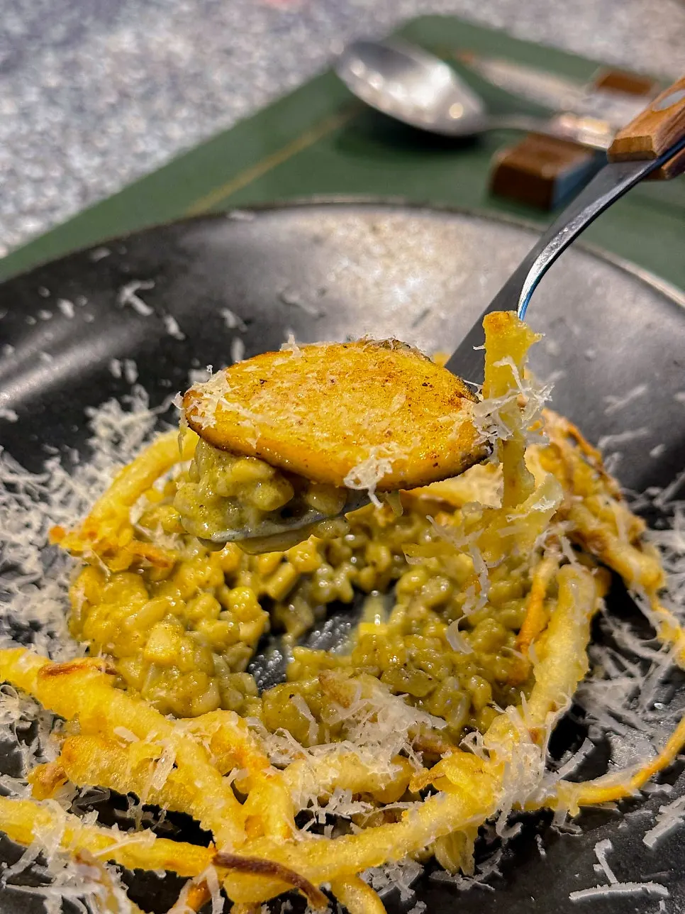 Close-up of abalone risotto topped with fried samchae herb