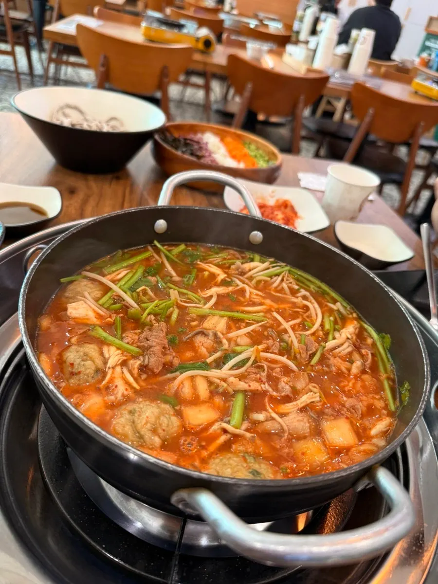 묵은지 육수와 미나리, 버섯이 담긴 샤브 냄비