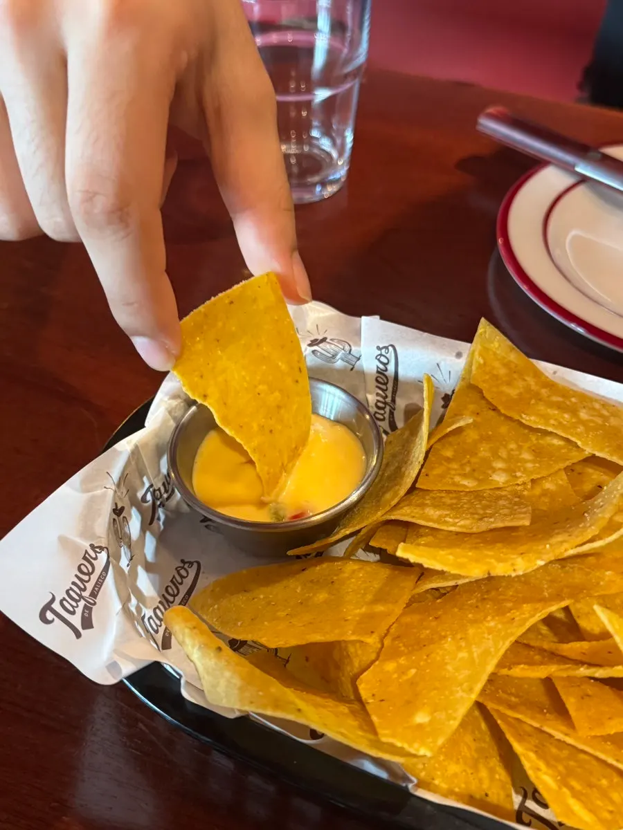 Nacho chips dipped in cheese sauce