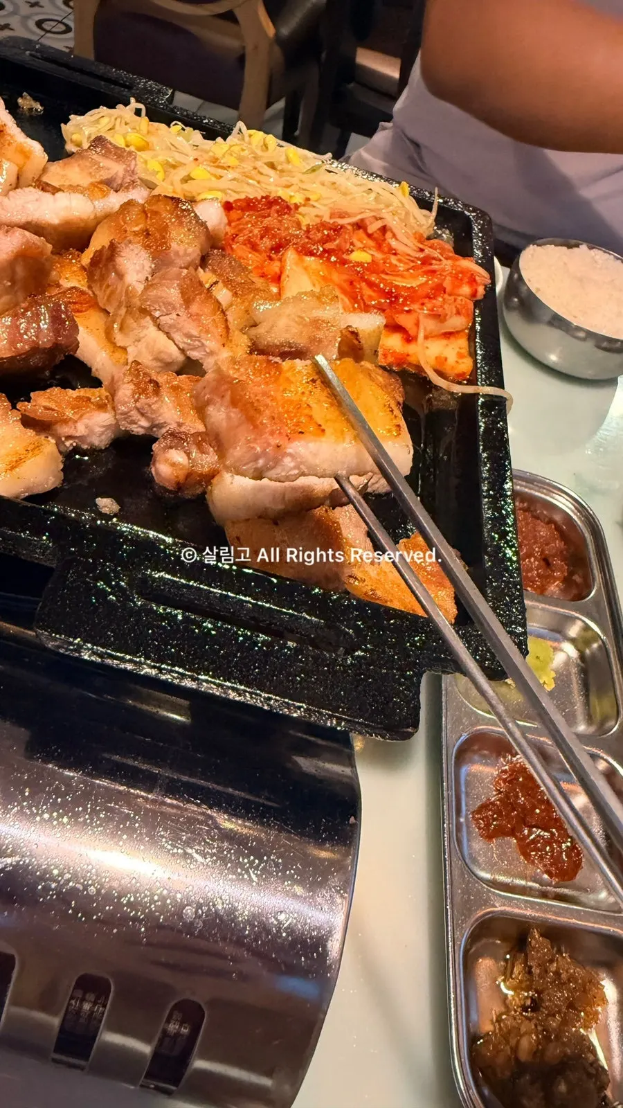 放上豆芽和泡菜的五花肉烤盘