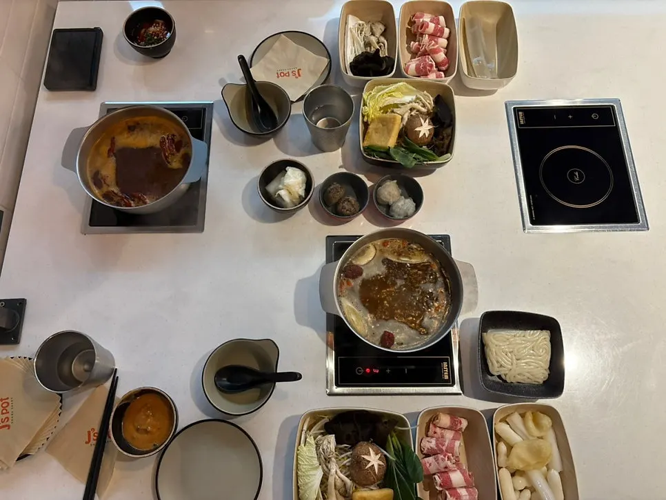 Table setup with mala hot pot and beef hot pot, one pot each