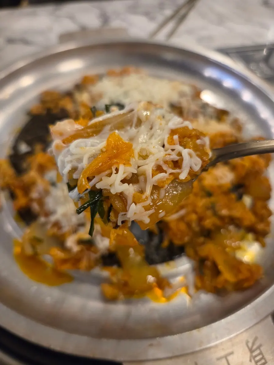 치즈 녹은 볶음밥을 한 스푼 뜬 모습