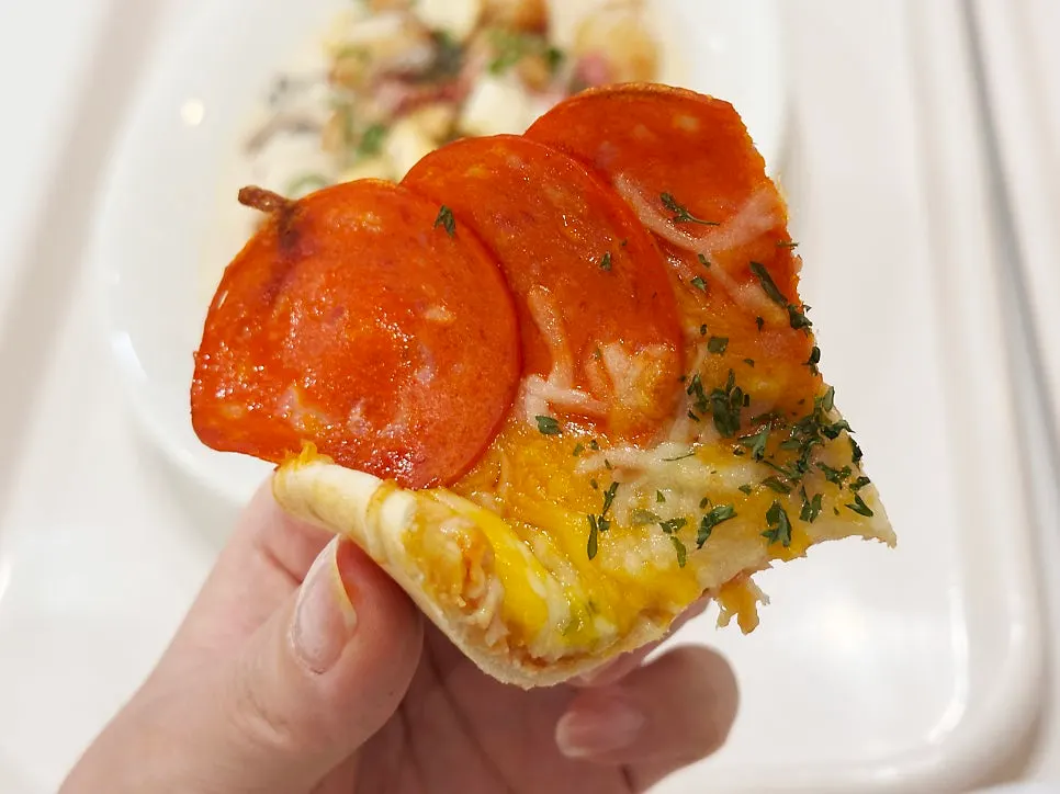 A slice of the pepperoni mini pizza cut into fourths