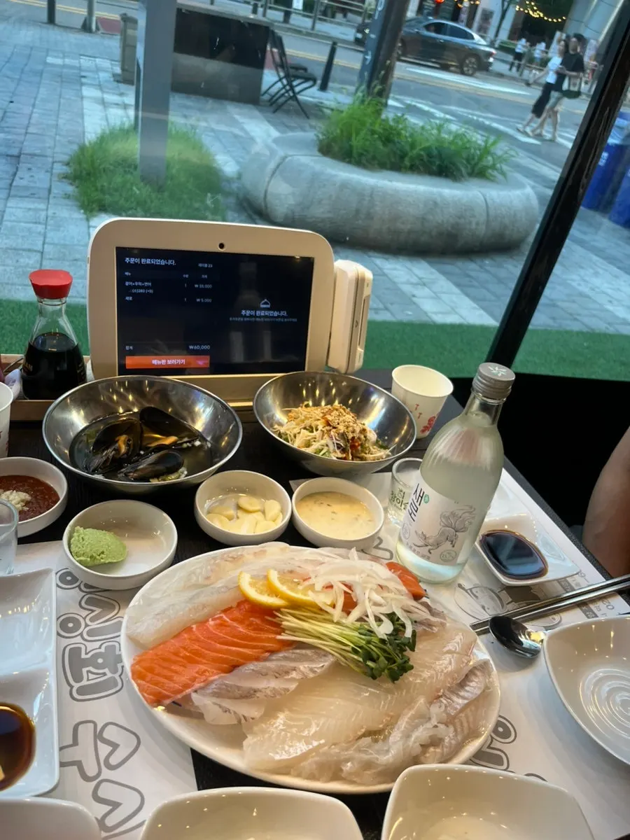 A full-table spread of raw fish and included side dishes