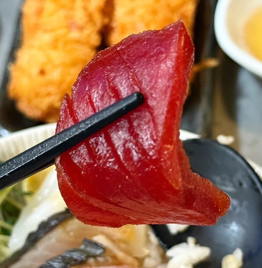 Sashimi lifted with chopsticks