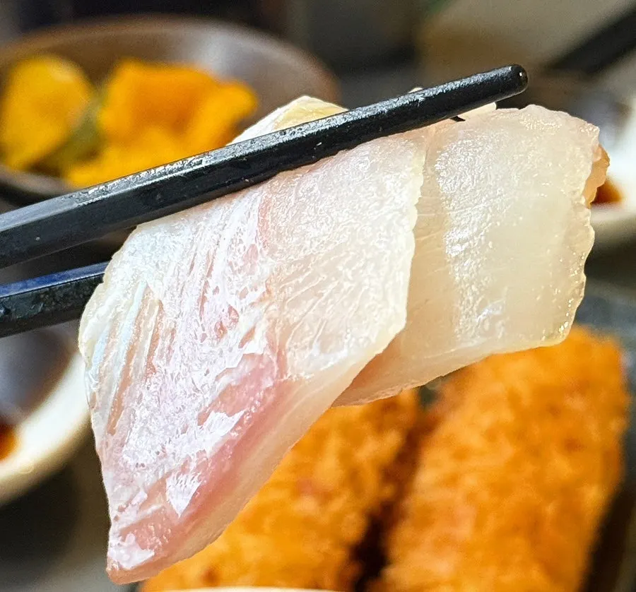 A bite of rice topped with sashimi