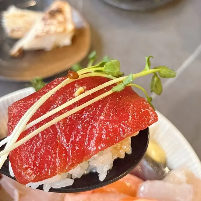 A piece of sashimi with soy sauce and wasabi
