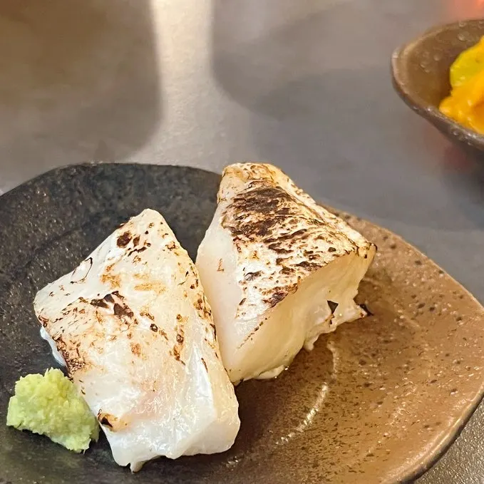 Complimentary grilled fish with a lightly torched surface
