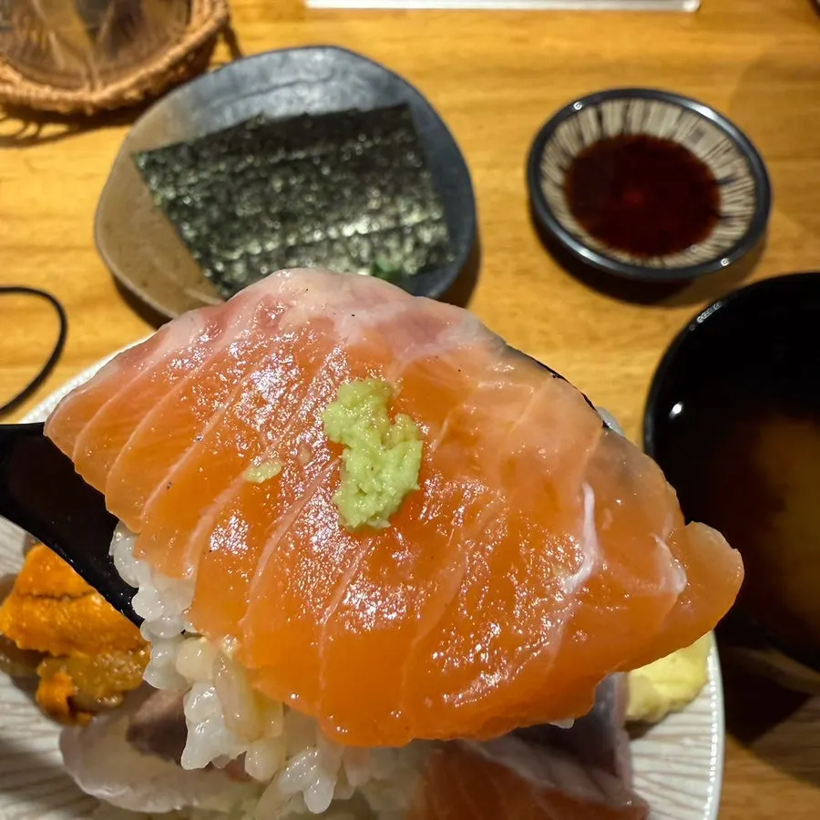 Sashimi placed atop rice and wasabi, sushi-style