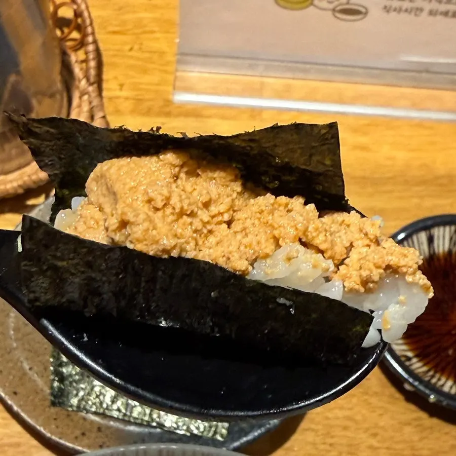 Wrapping ankimo and rice in gim