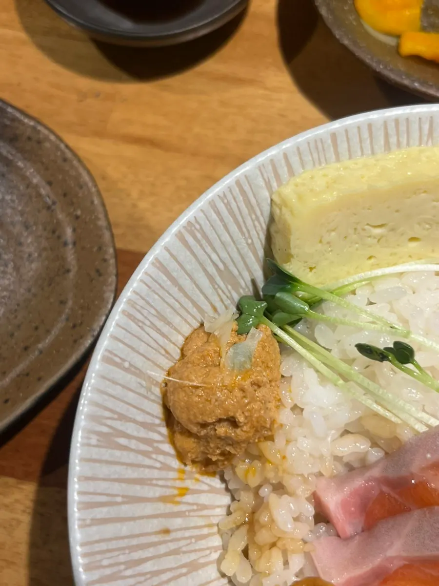 A bite of seaweed with rice, wasabi, and herring