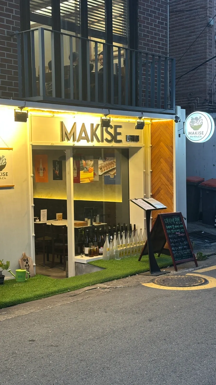 Makise Hapjeong's exterior lit up in the evening