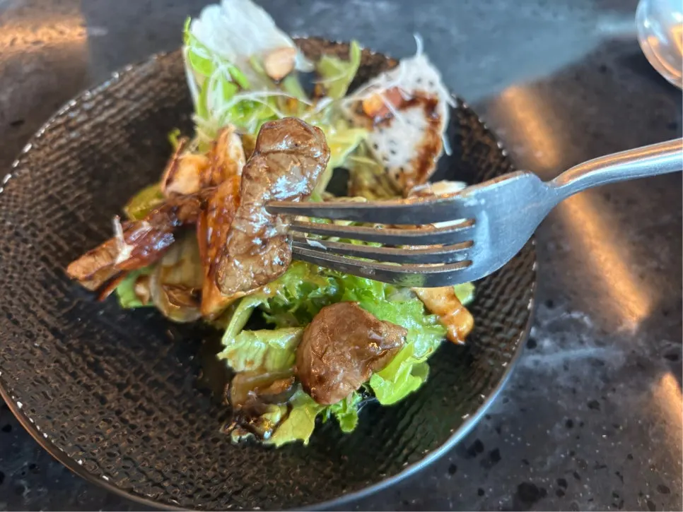 Close-up of beef salad topped with beef and avocado