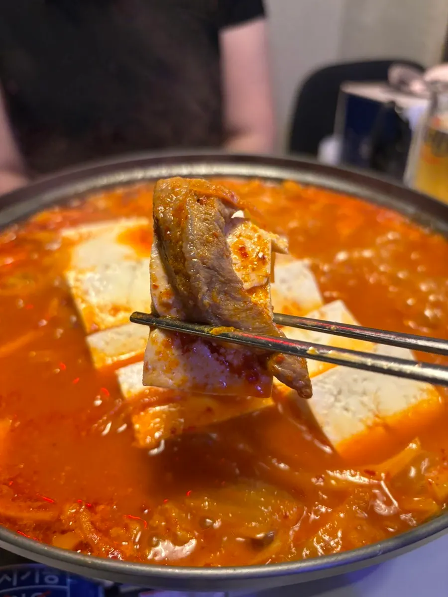 연맥 잔과 김치찜이 함께 놓인 테이블