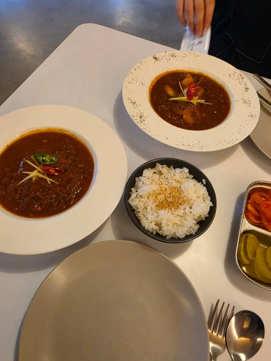 Chicken tikka masala, shrimp masala, and steamed rice set on the table