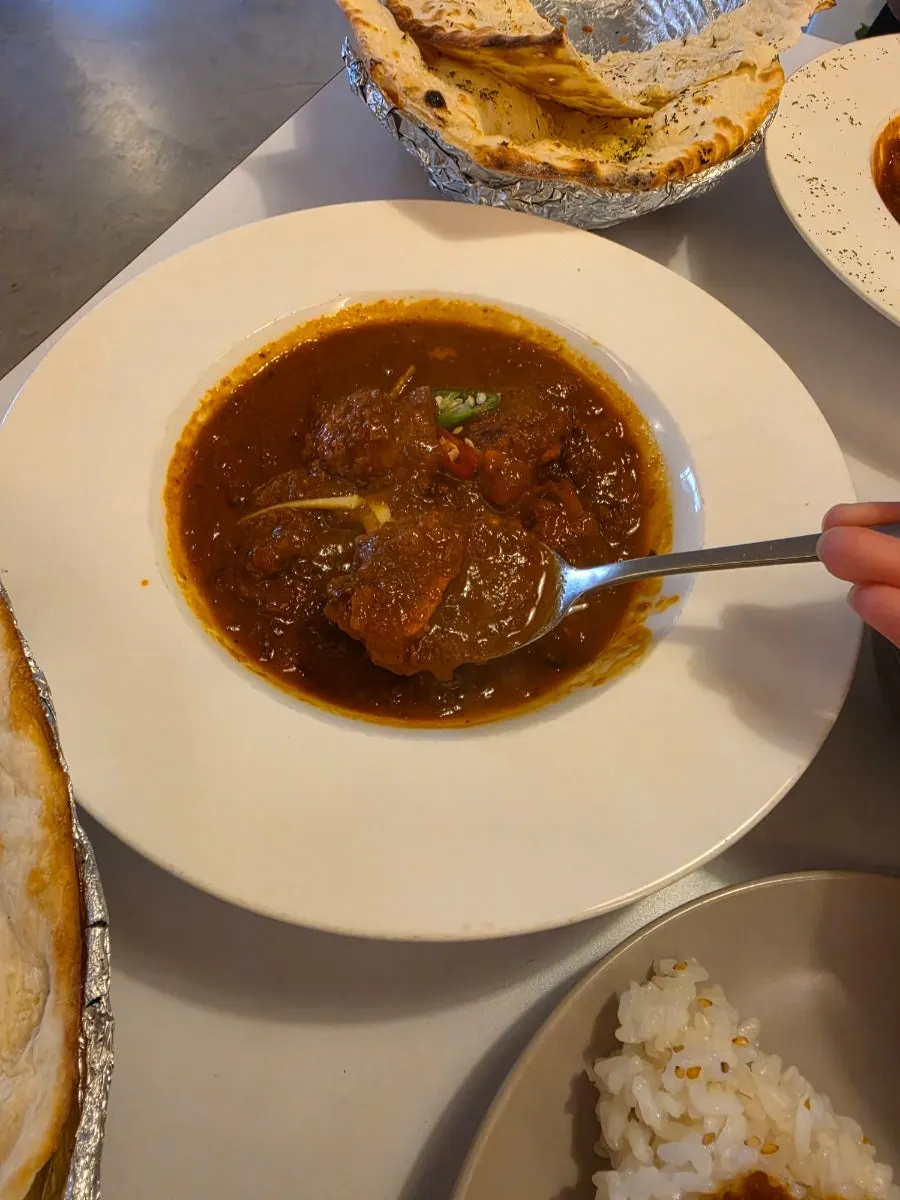 Dipping naan into the curry