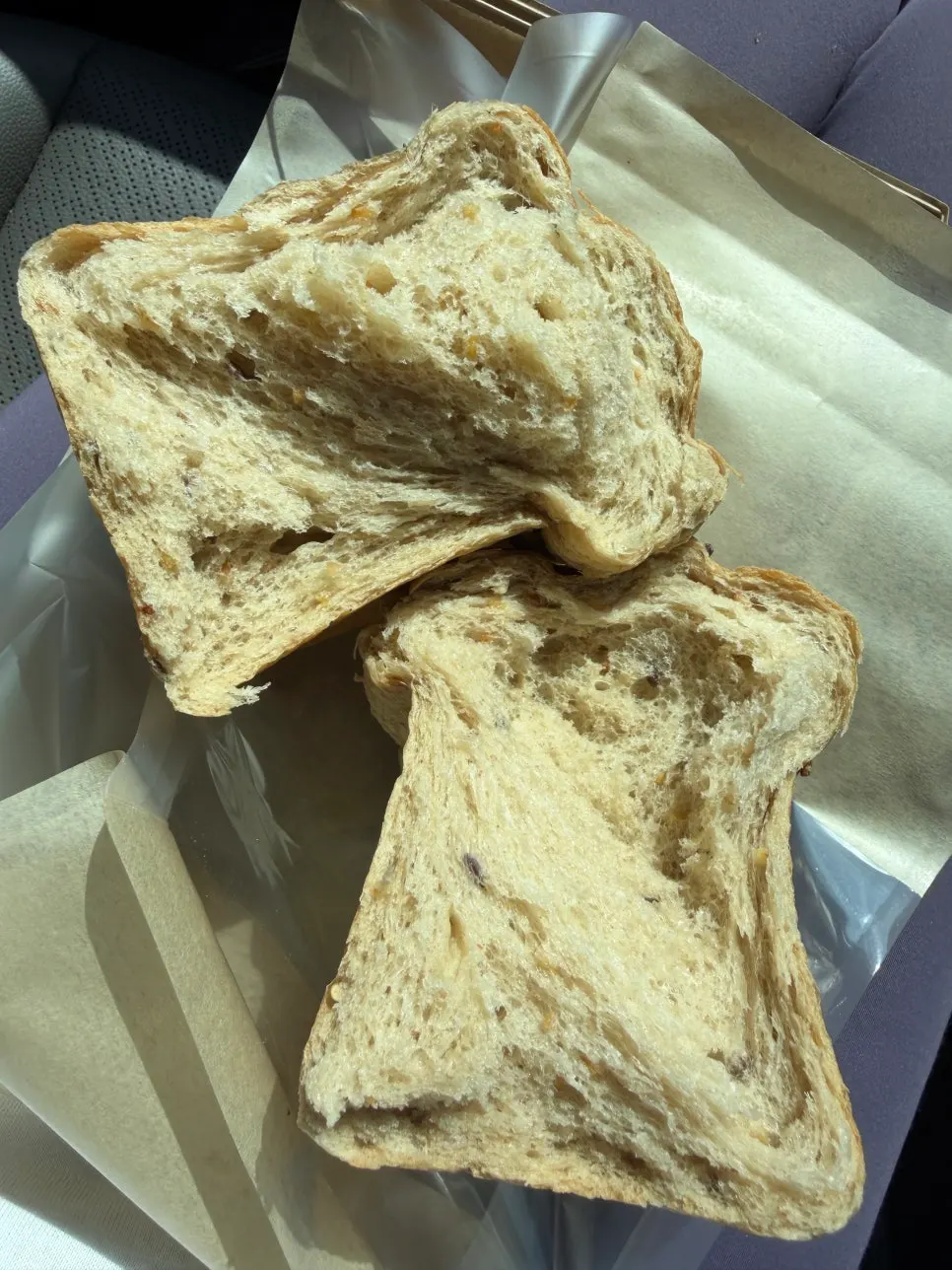 Grain bread torn open by hand showing its crumb