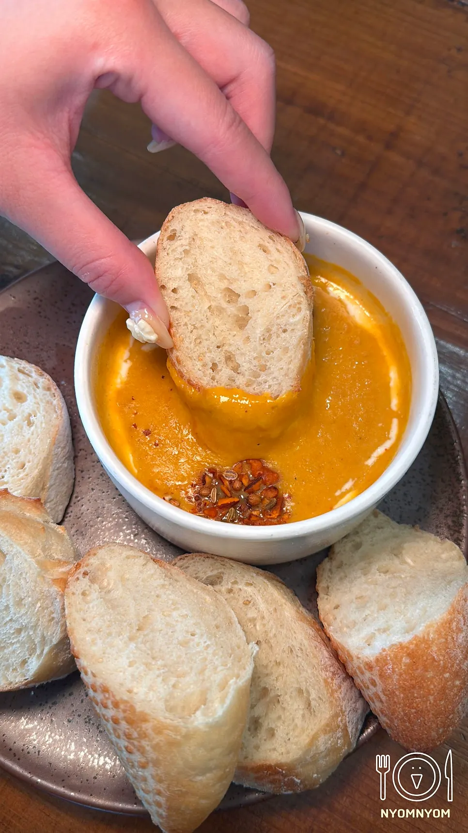 House baguette being dipped into the soup