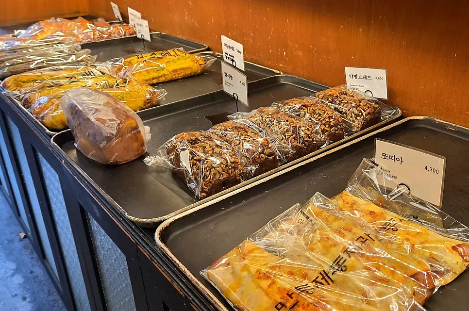 Bread on the wooden display shelves inside Mandong Jegwa Yeonnam Branch