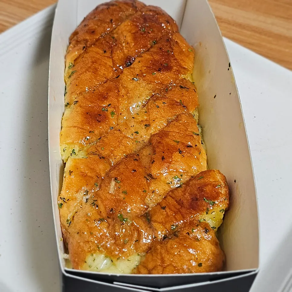 칼집이 촘촘한 마늘바게트와 종이 박스
