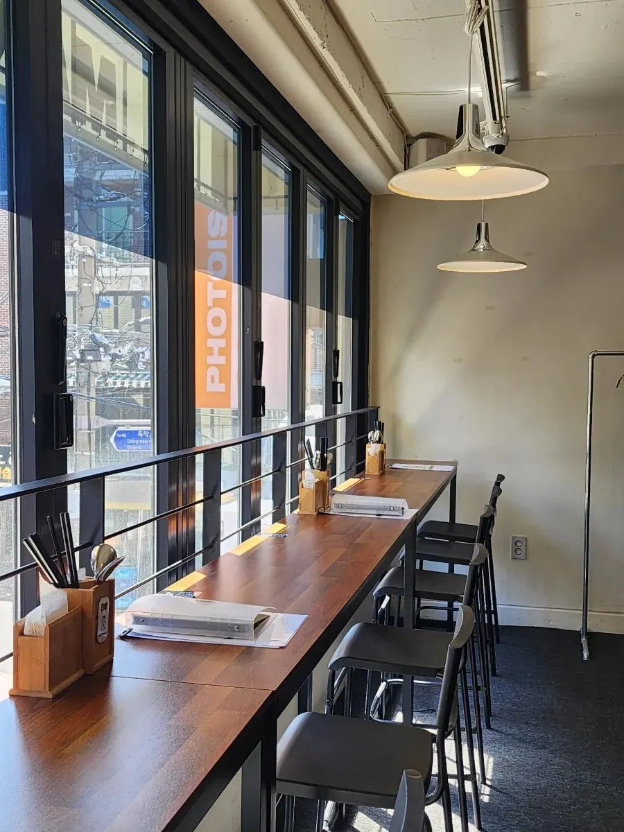 Bar seating by the folding-door windows at MANDOO BAR
