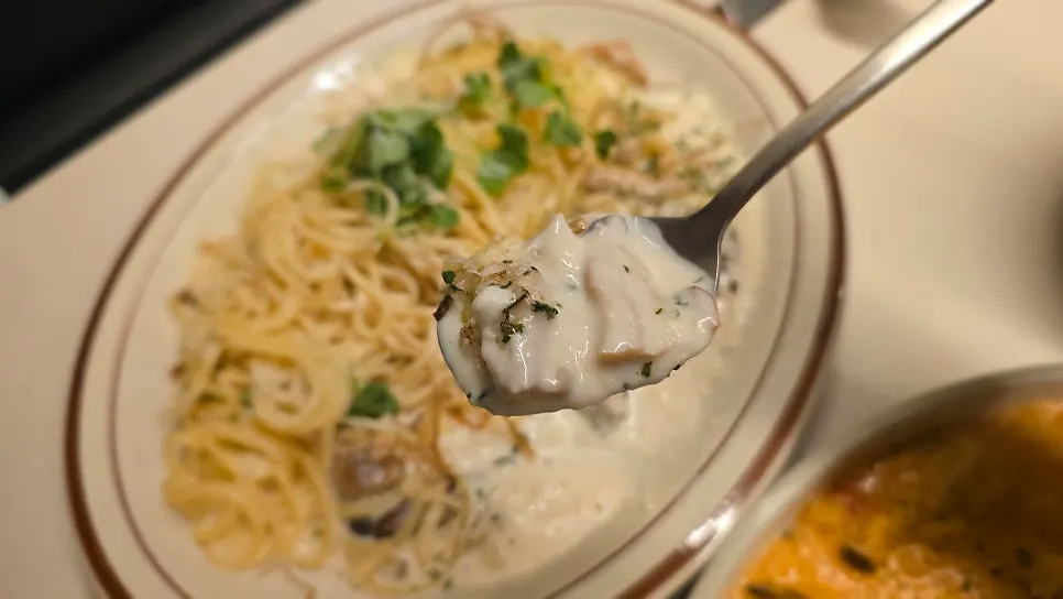 Cream pasta topped with grilled enoki mushrooms