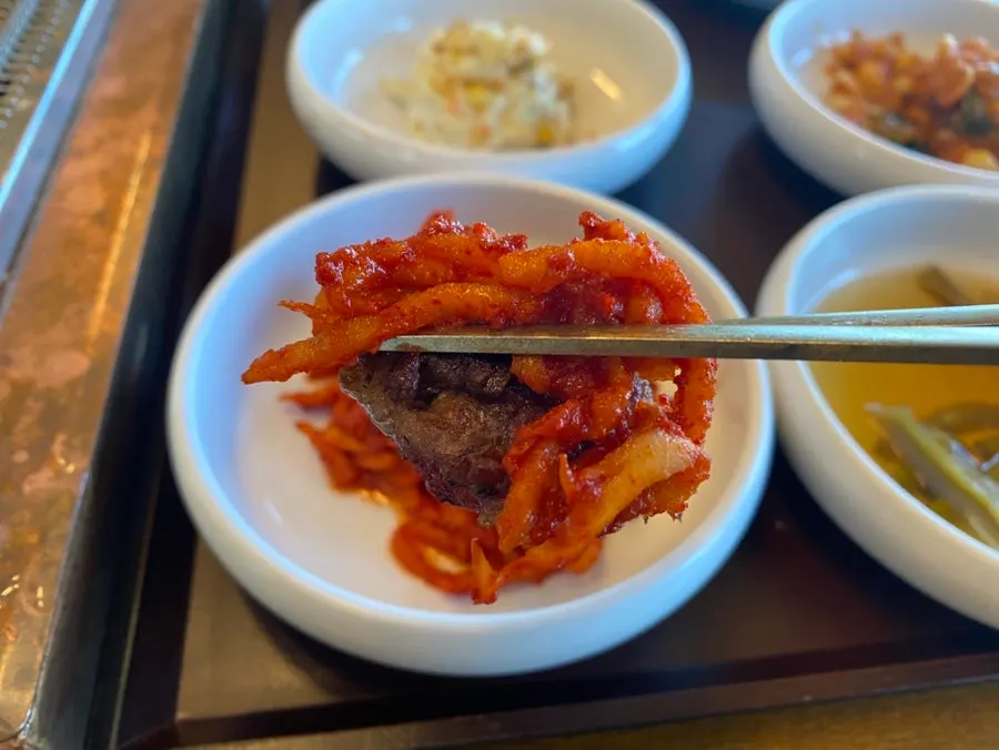 Seasoned galbi paired with scallion strips and pickled gungchae