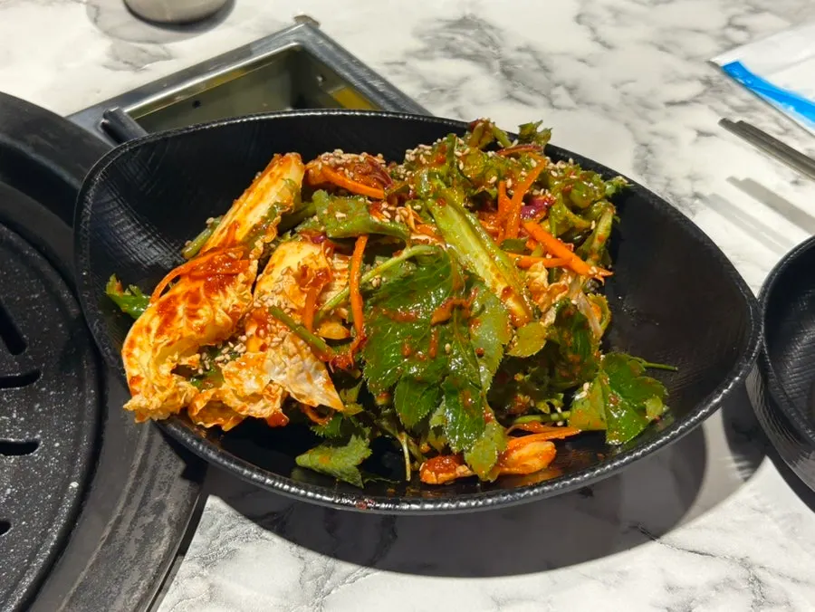 Đồ ăn kèm gồm myeongi và kimchi cải trộn
