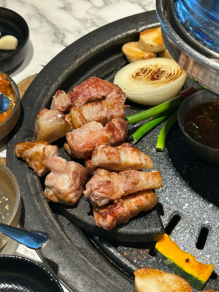 Thịt chín vàng được gắp lên góc bếp nướng