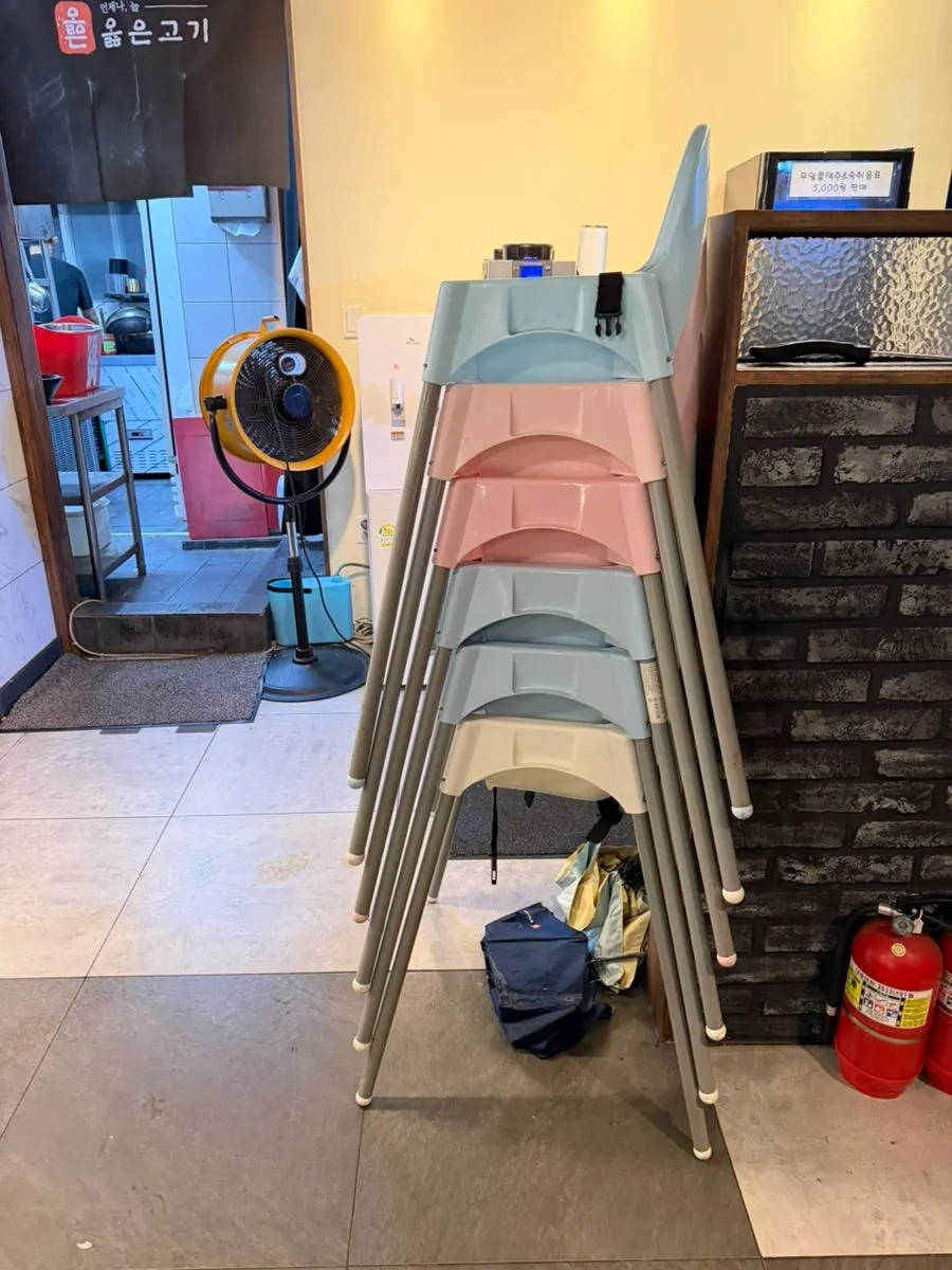 Baby chairs stacked and signage at the entrance