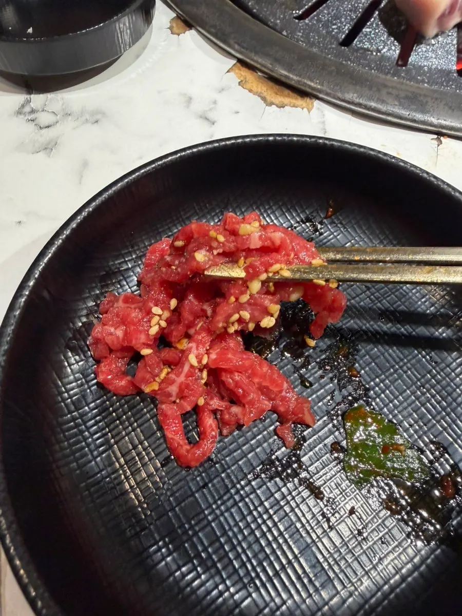 A piece of yukhoe dipped in egg yolk