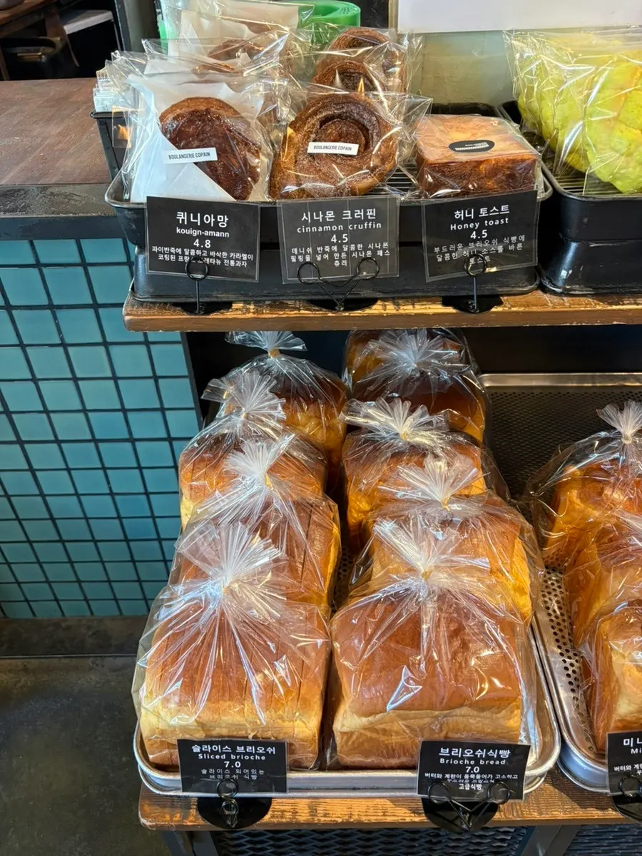 Picking bread with tongs and a tray at the display case