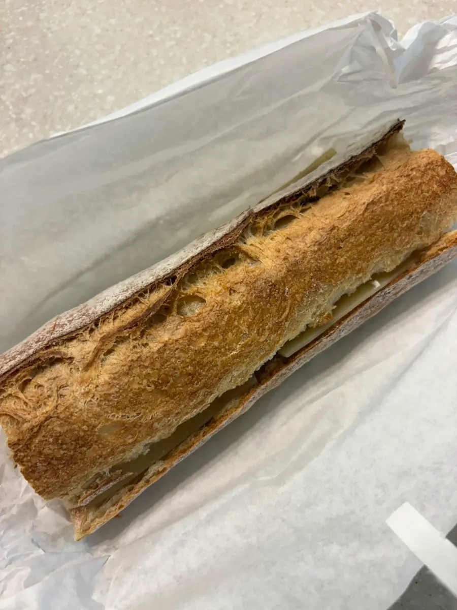 Ham-cheese baguette sandwich wrapped in packaging