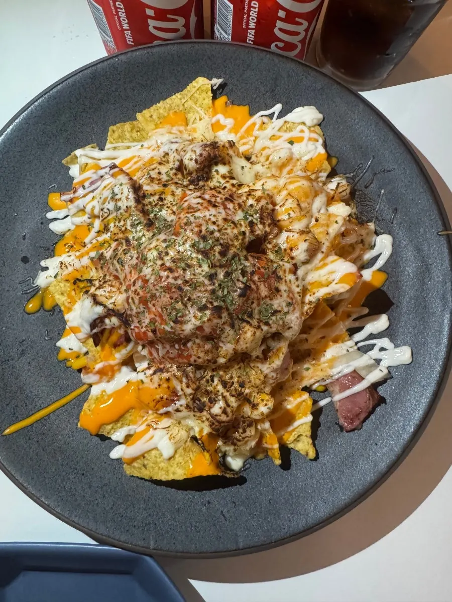 치즈와 우삼겹을 올려 집은 나초 한입