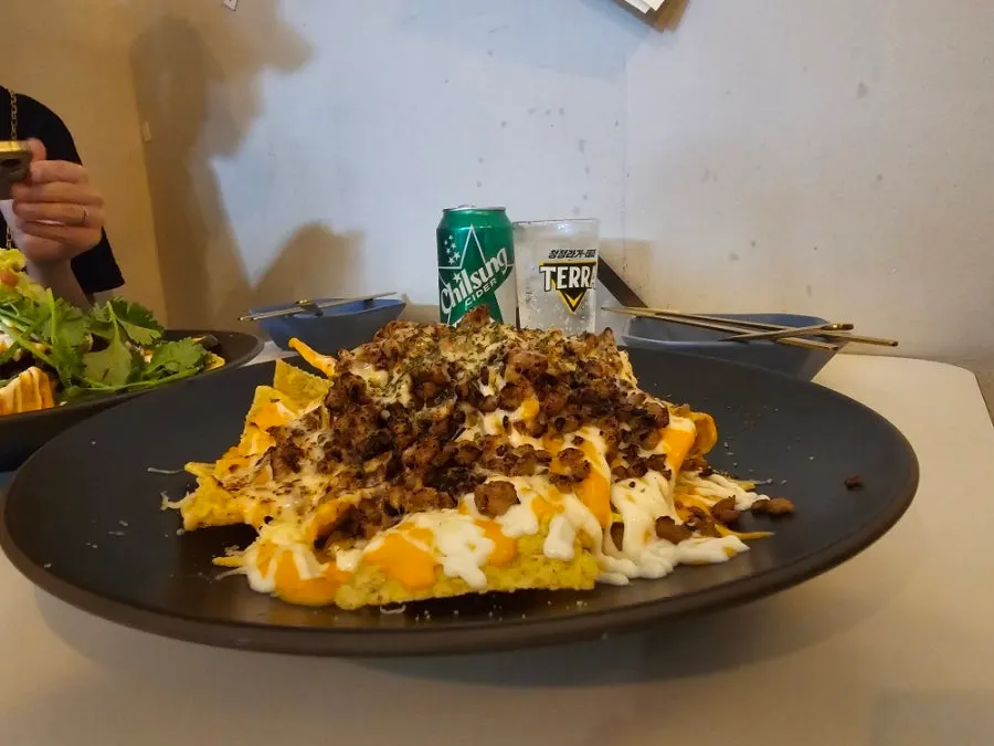 A bite of nachos combining minced meat and cheese