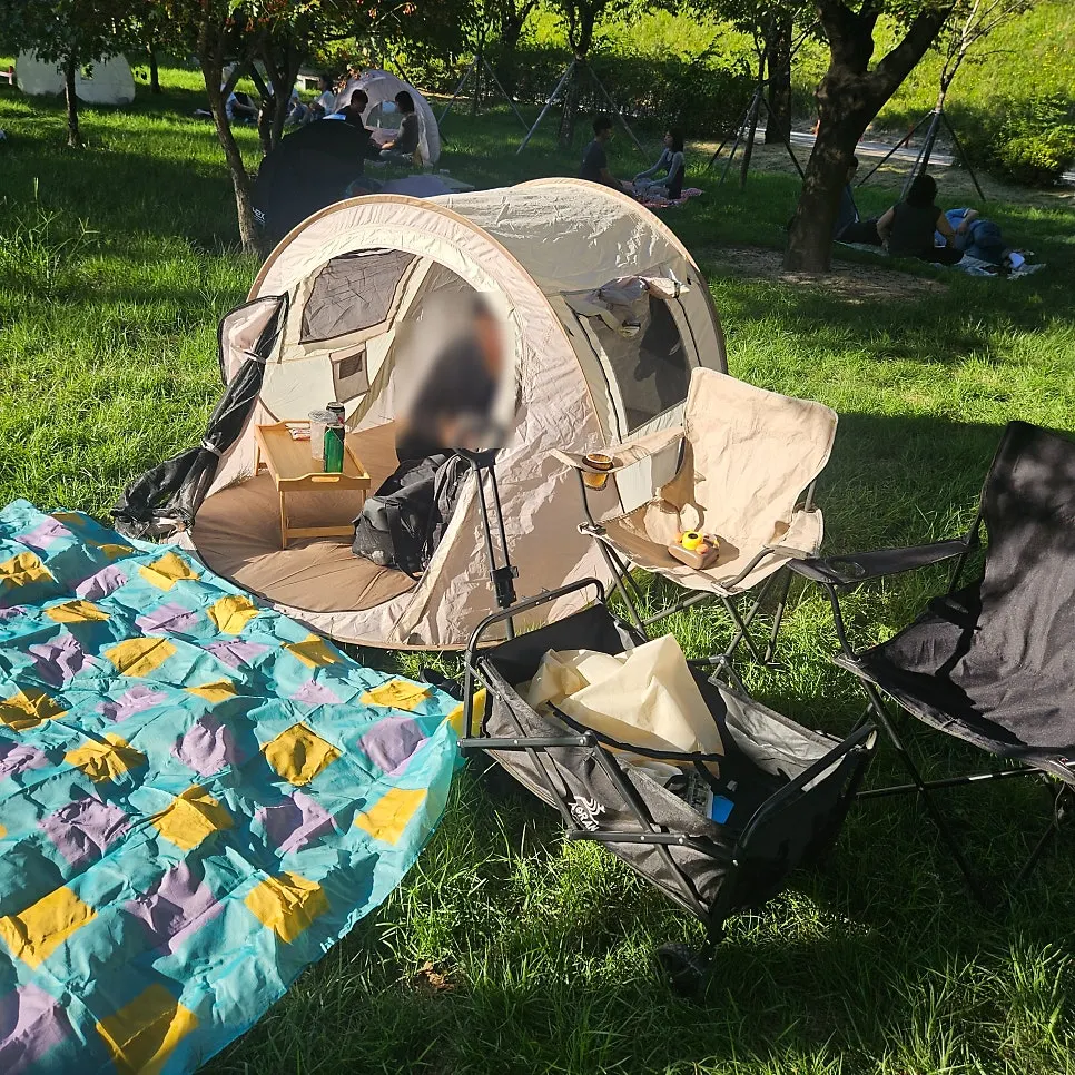 Mat laid out and camping chairs set up in front of the tent