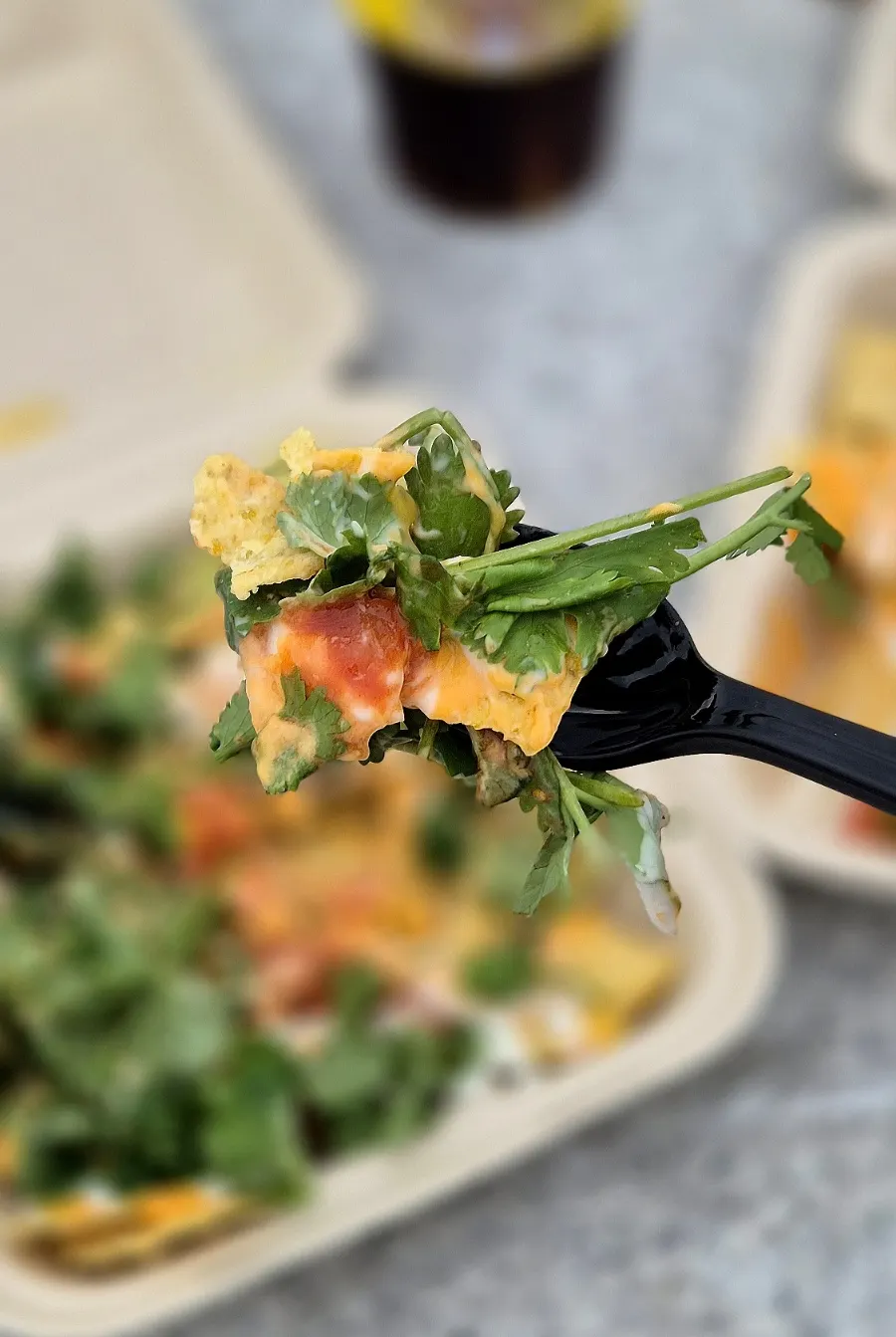 Scooping up mixed toppings from the cilantro nacho