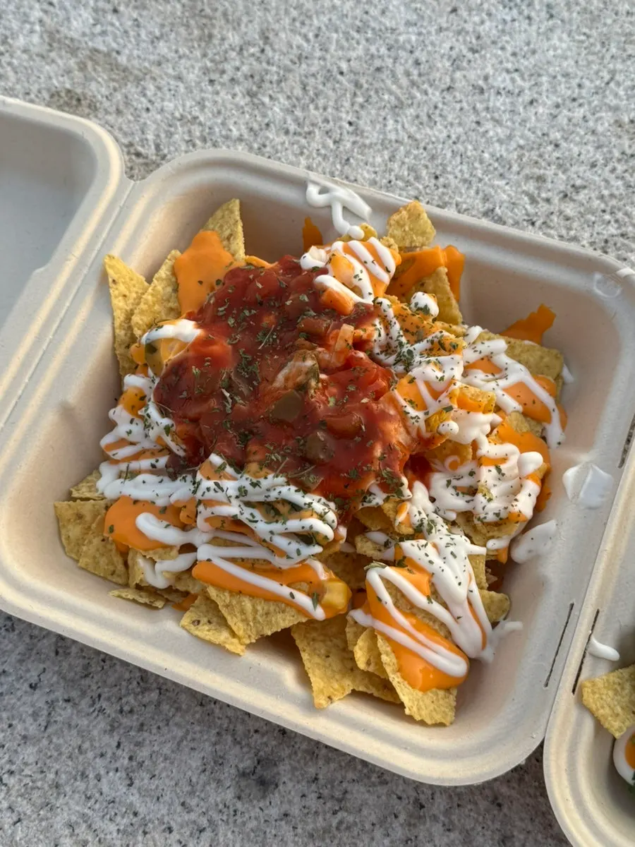 Nacho platter and canned beer set up on a mat by the Han River