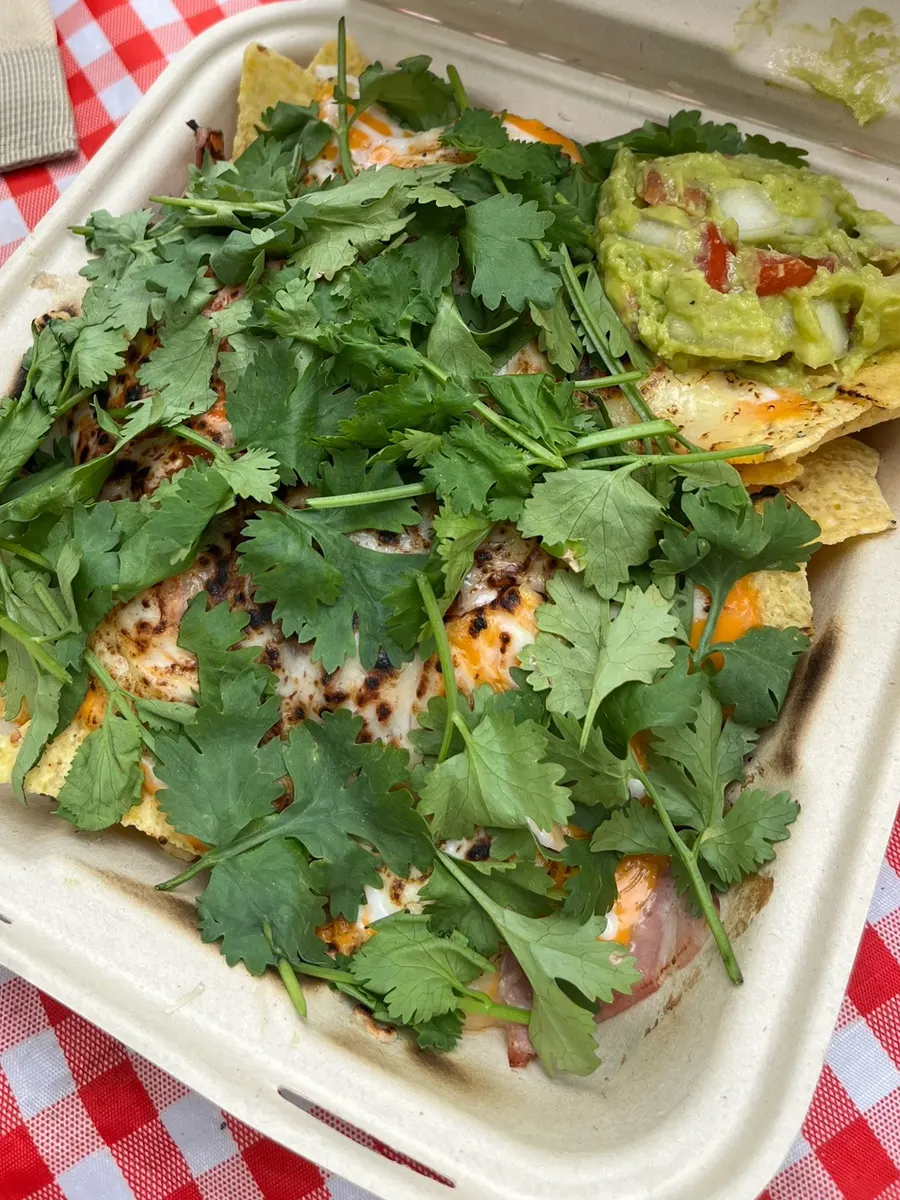 Picnic table topped with takeout pizza and coke