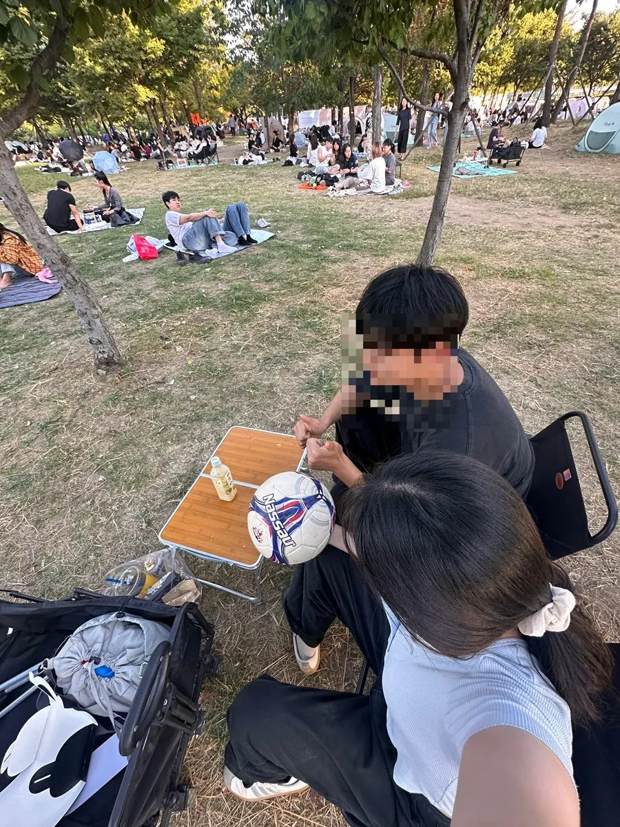 Picnic spot set up with a wood table and camping chairs by the Han River