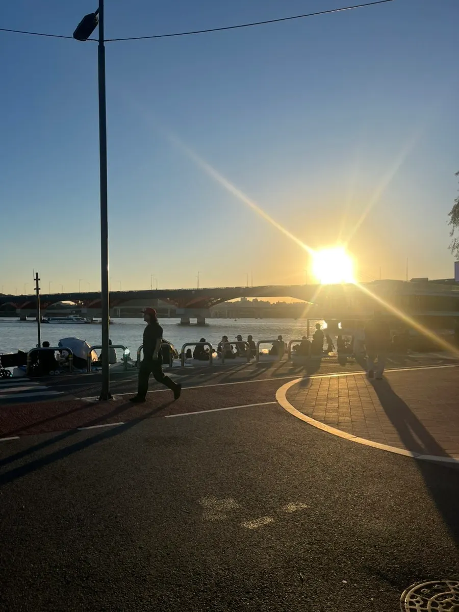 Han River picnic spot with a Bluetooth speaker and wine table