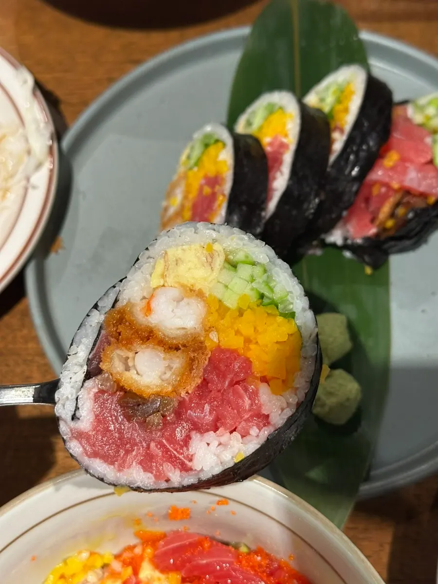 A piece of futomaki lifted onto a spoon