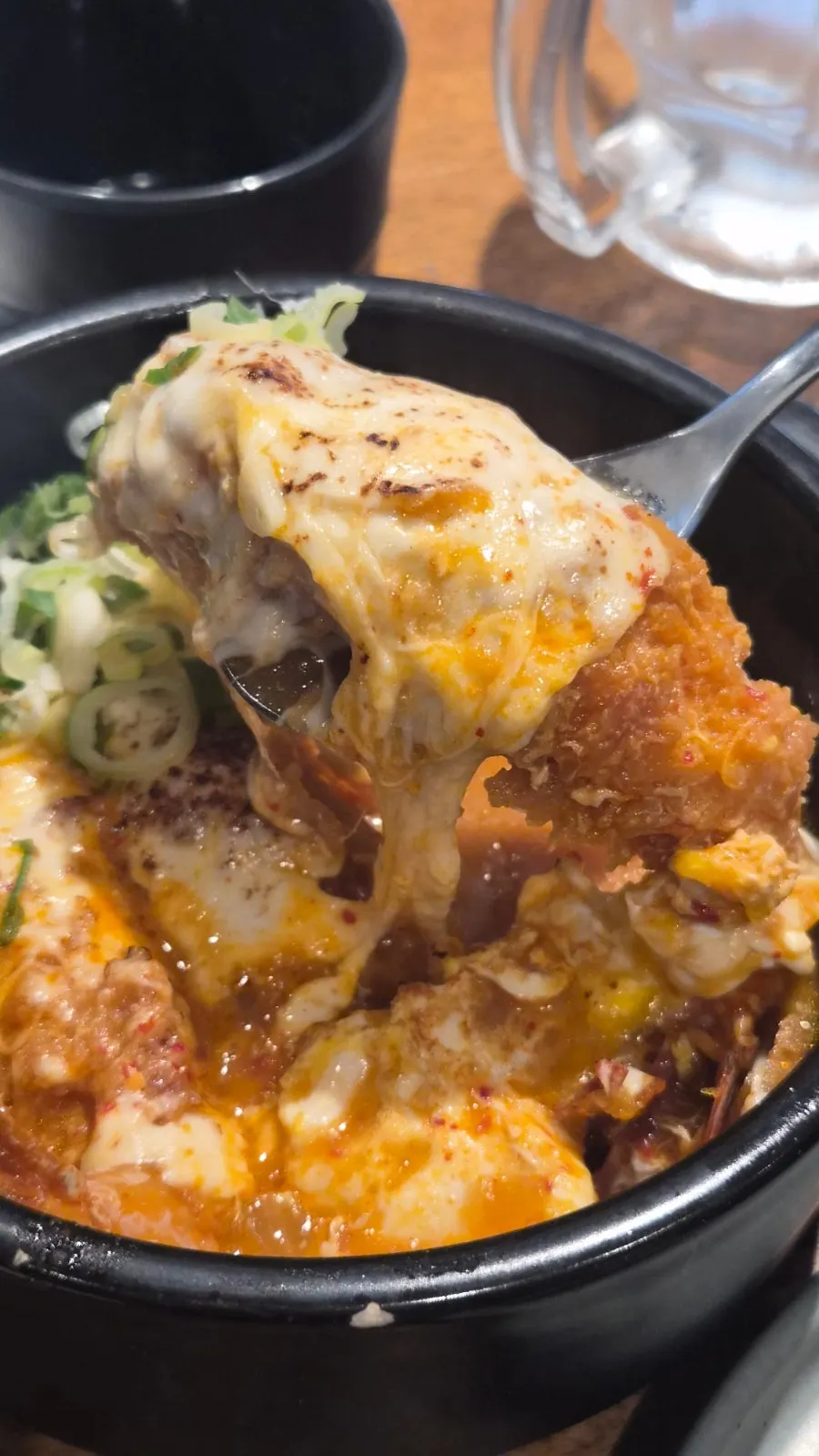 Kimchi nabe topped with mozzarella cheese and fried shrimp