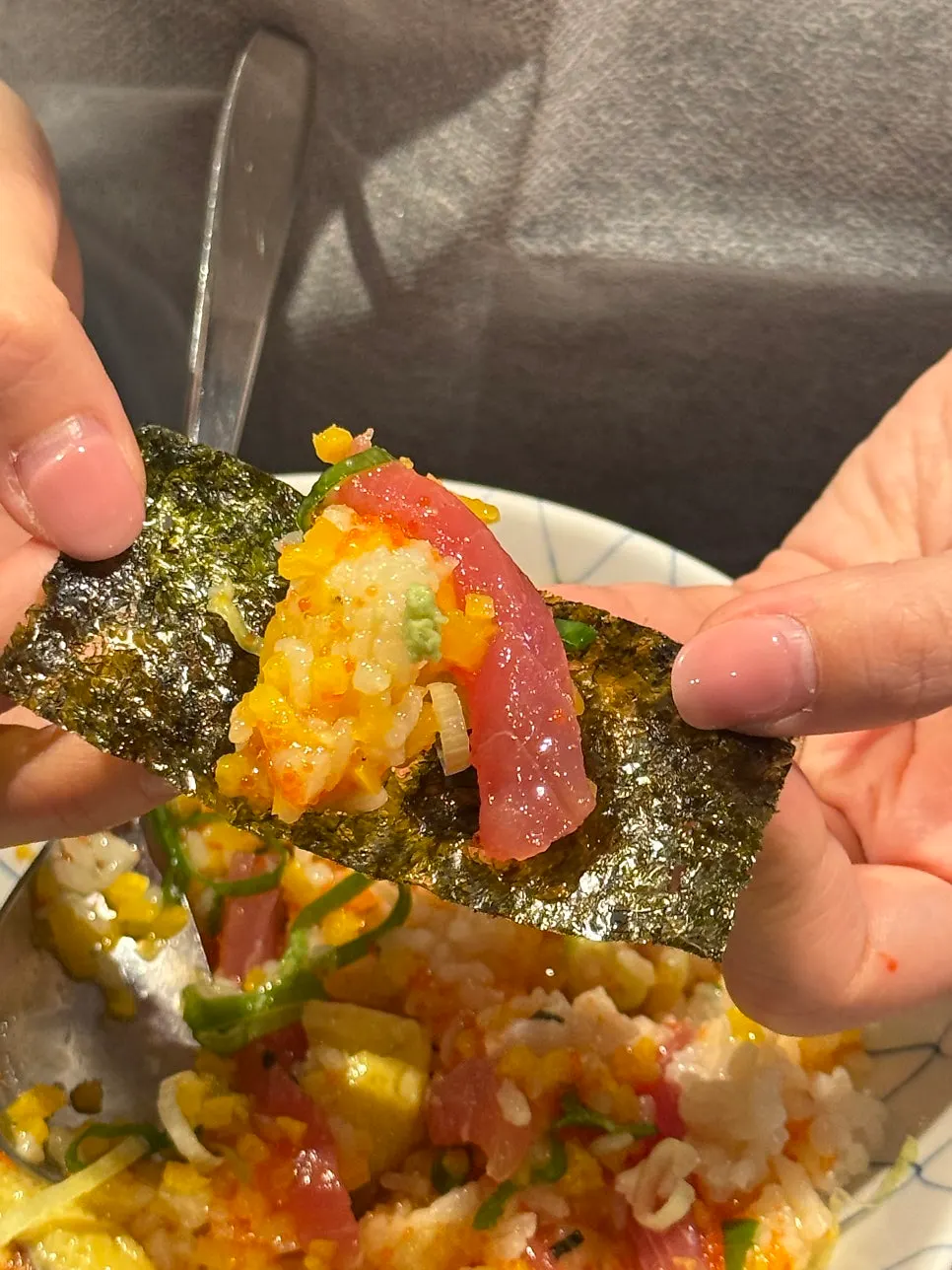 A bite of Padong's tuna rice bowl wrapped in seaweed
