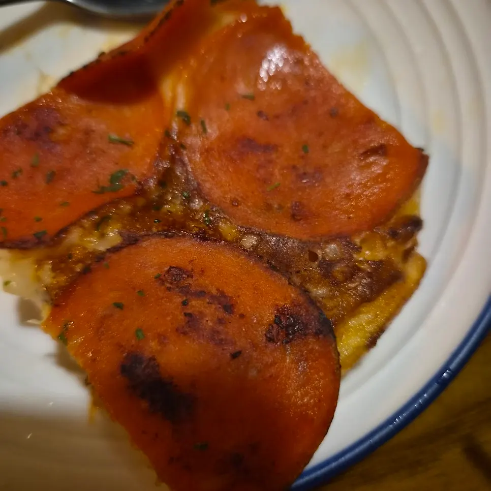 A slice cut from the pepperoni potato pancake