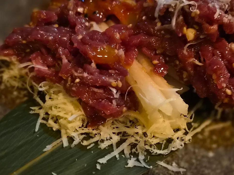 Picking up hanwoo cheese yukhoe with chopsticks