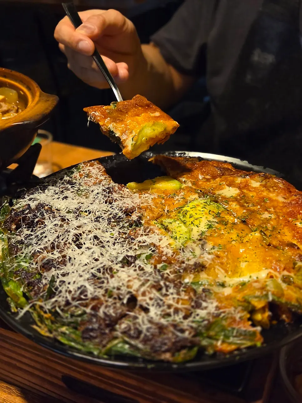A piece of cheese kimchi pancake lifted from the plate