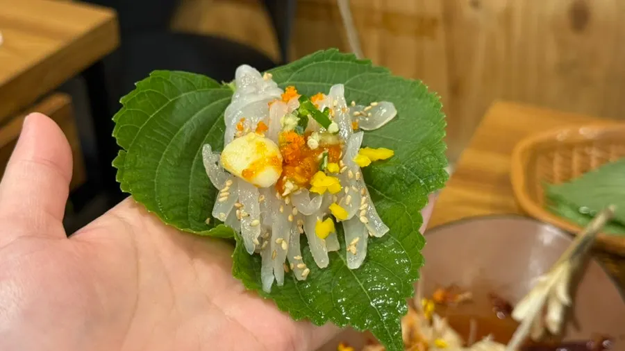 Perilla leaf wrap with live squid sashimi and flying fish roe