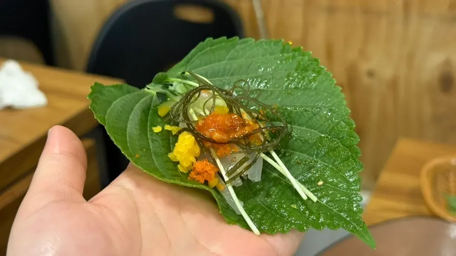 Live squid sashimi wrapped in kelp